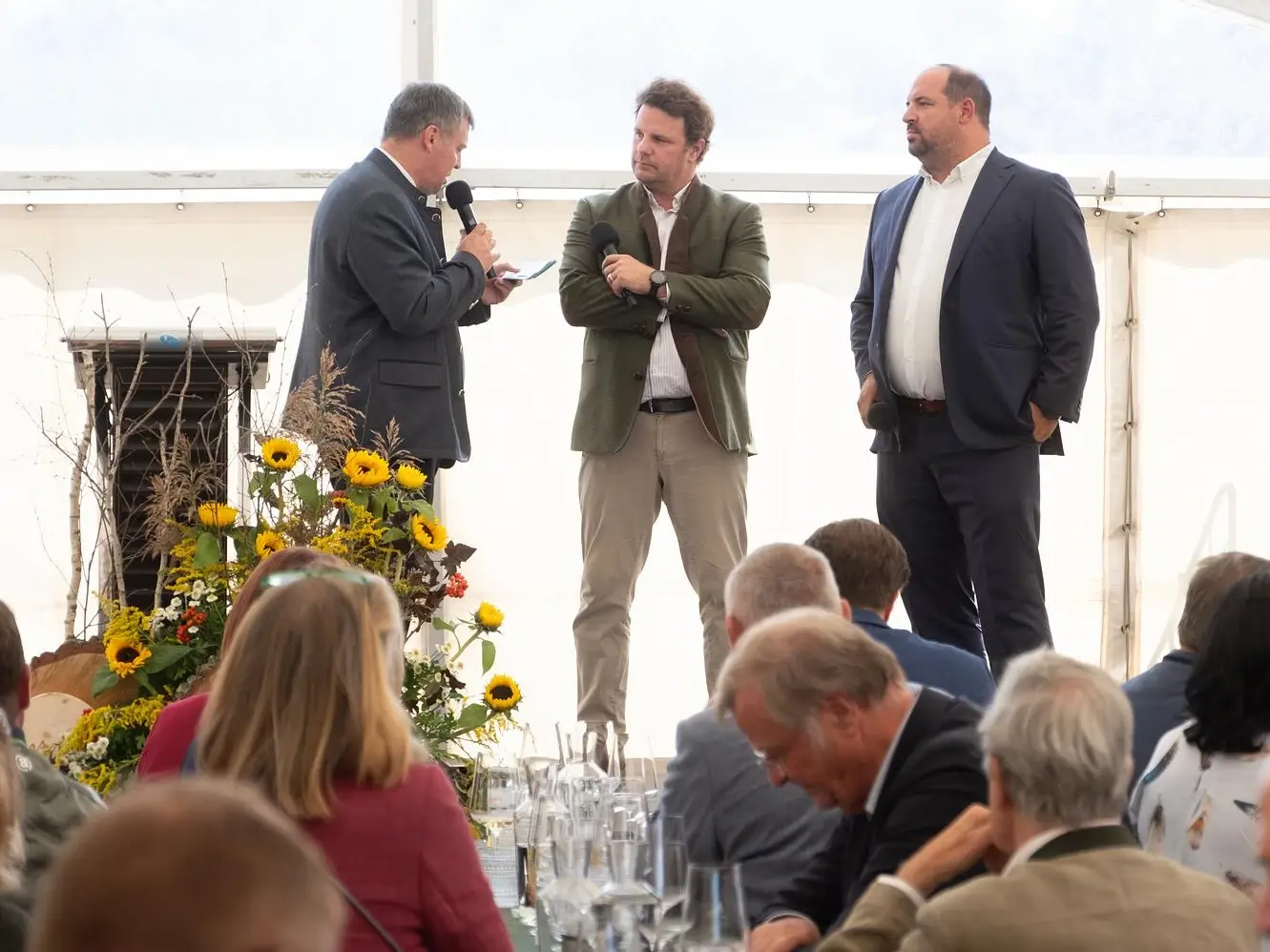 Podiumsgespräch im Festzelt: ein Moderator mit den Geschäftsführern Franziskus Seilern-Aspang und Georg Hauer, davor die Gäste an den Tischen